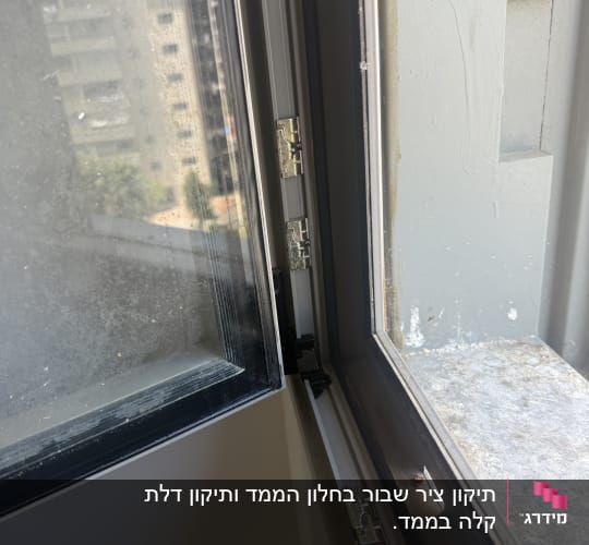חלון פתוח עם צירים ומסגרת מתכת